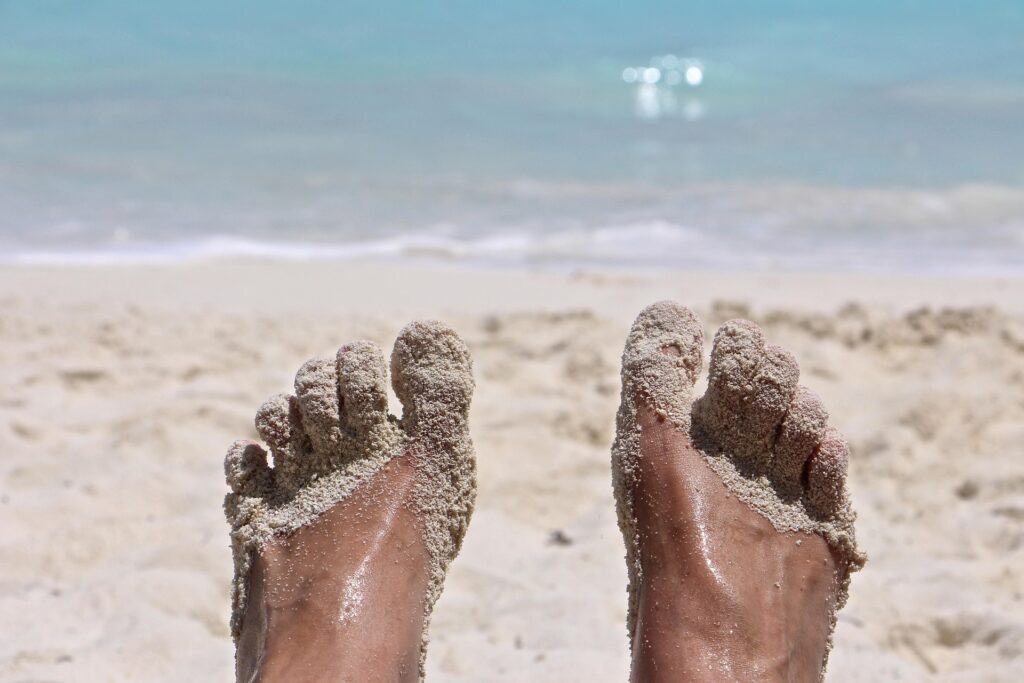 a person's feet covered in sand