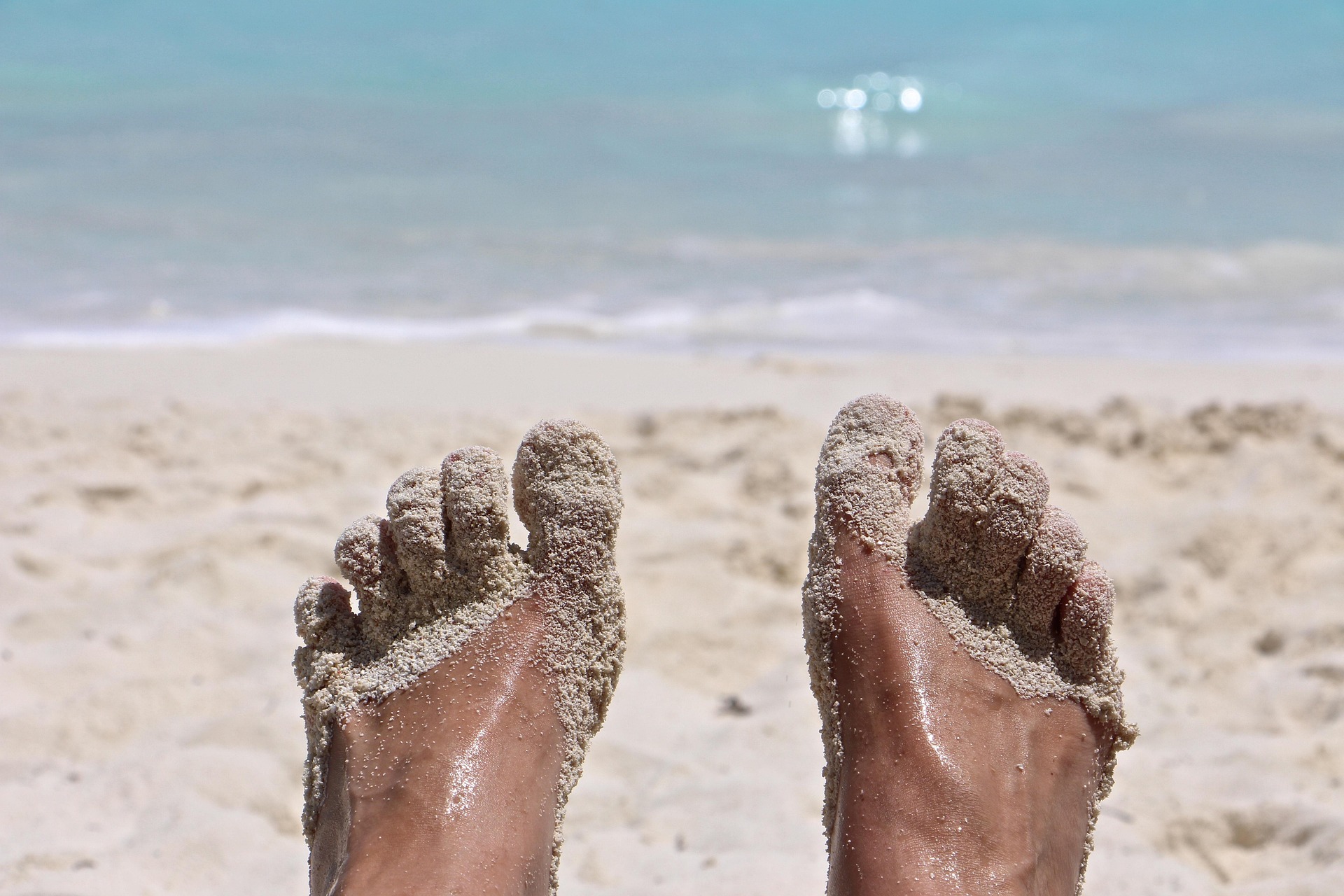 a person's feet covered in sand